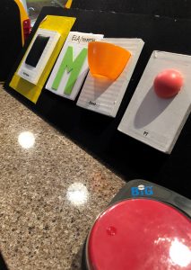 An array of four items are arranged on a velcro board propped up on a table.