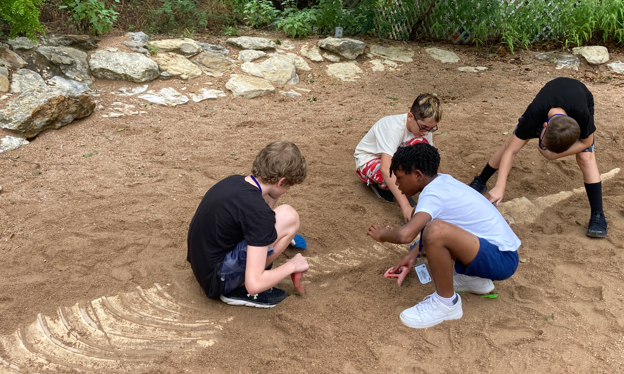 student digging in the soil at dinosaur park