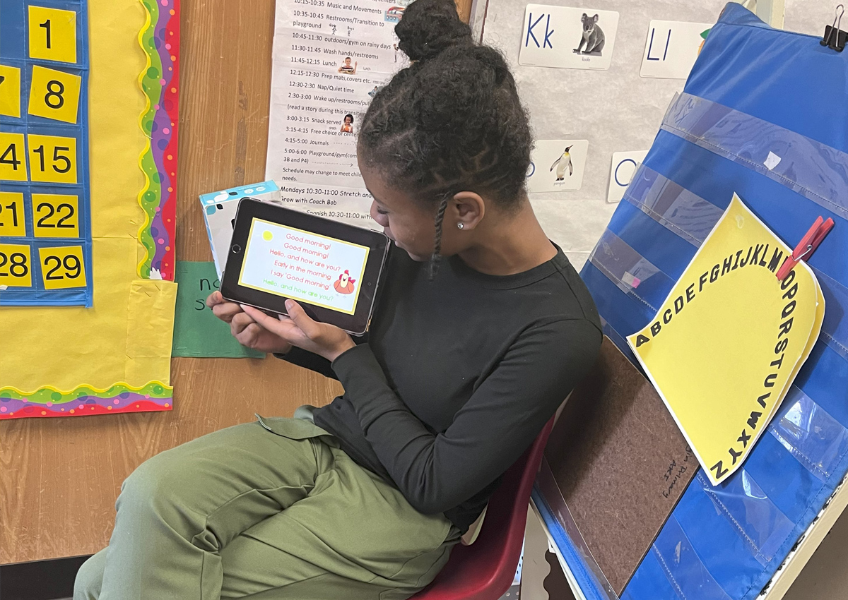 An adolescent holds an iPad with a 