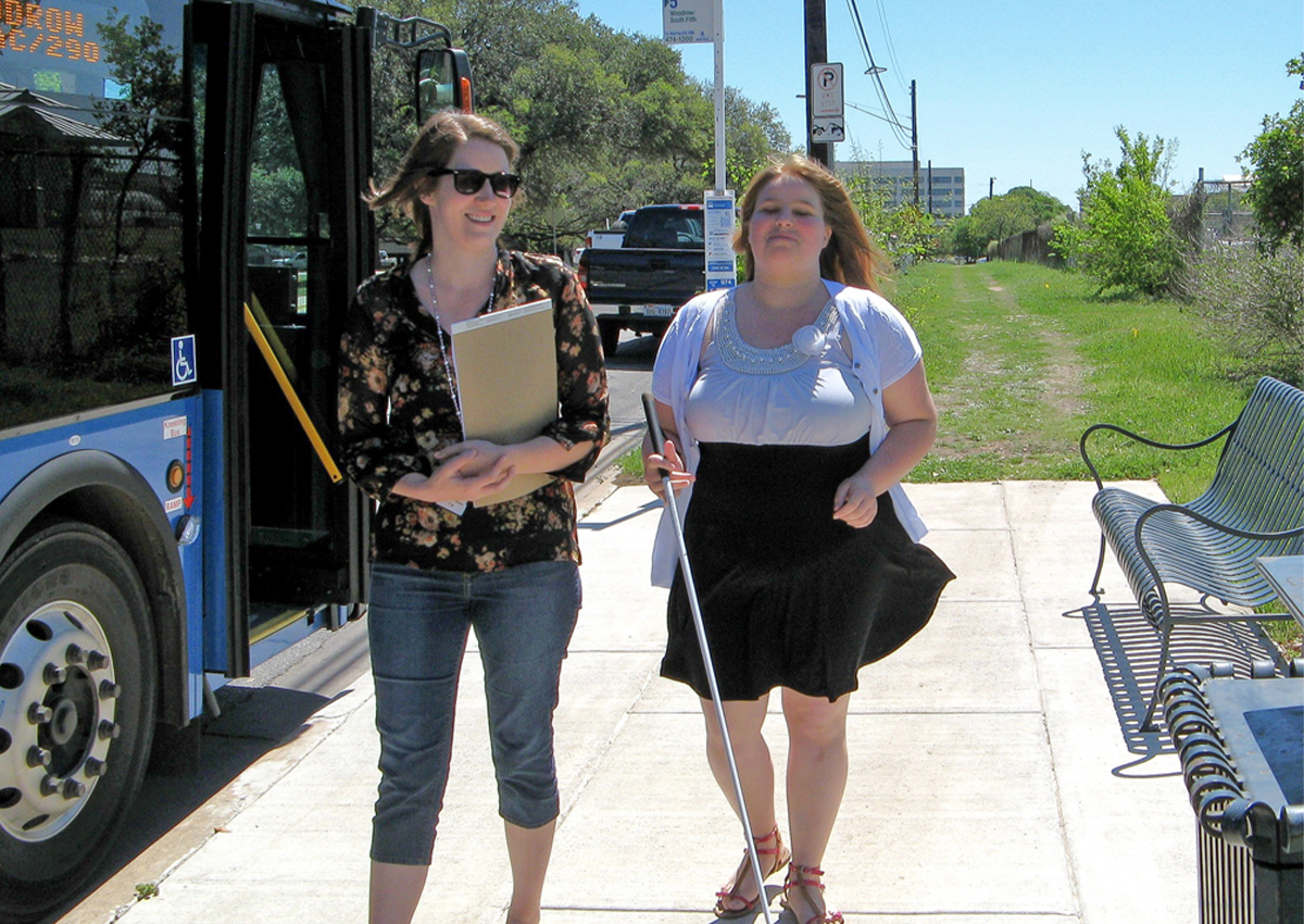 Staff and student depart a city bus.