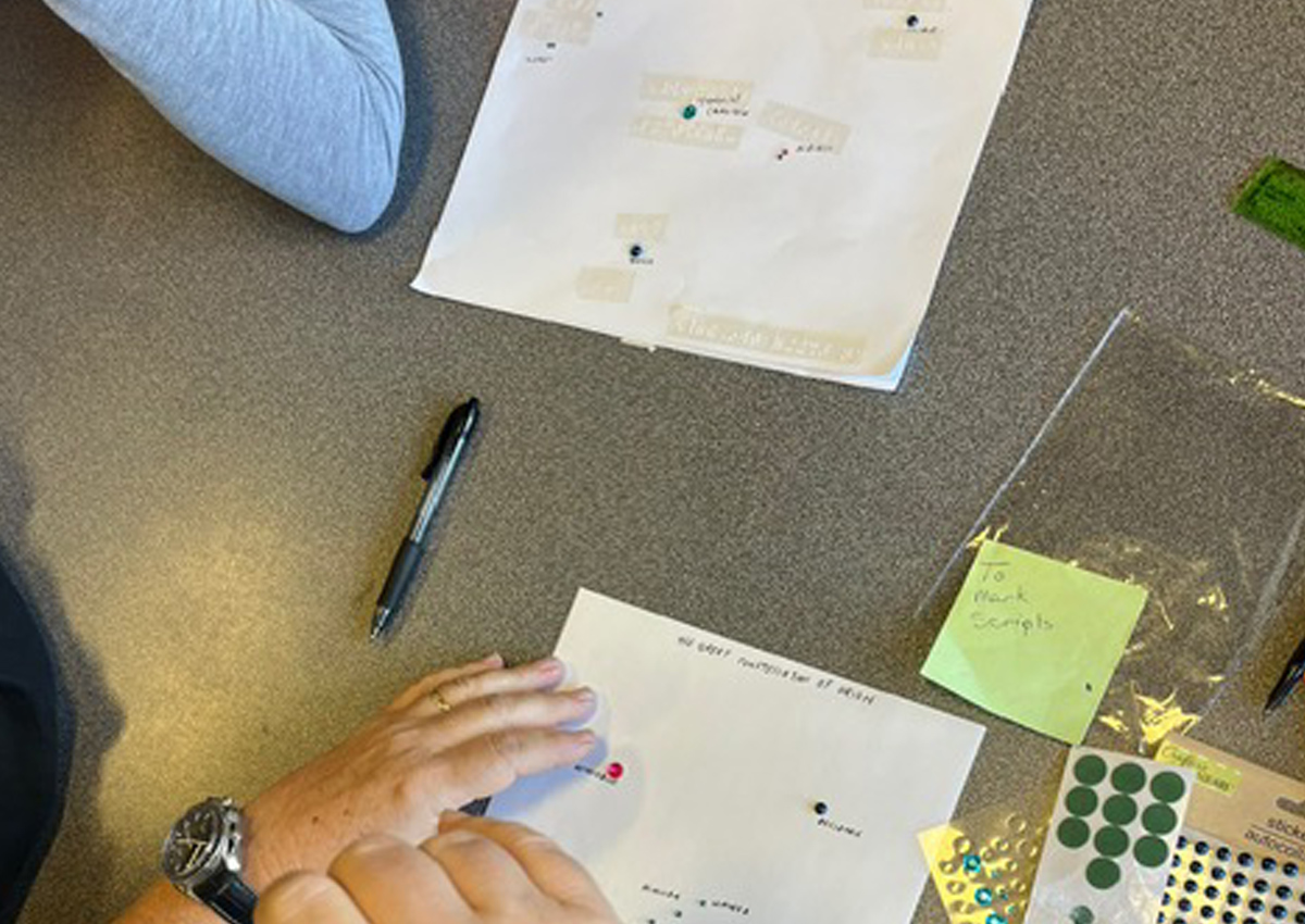 Two pages of braille paper with tactile dots and braille labels representing different constellations on a table.
