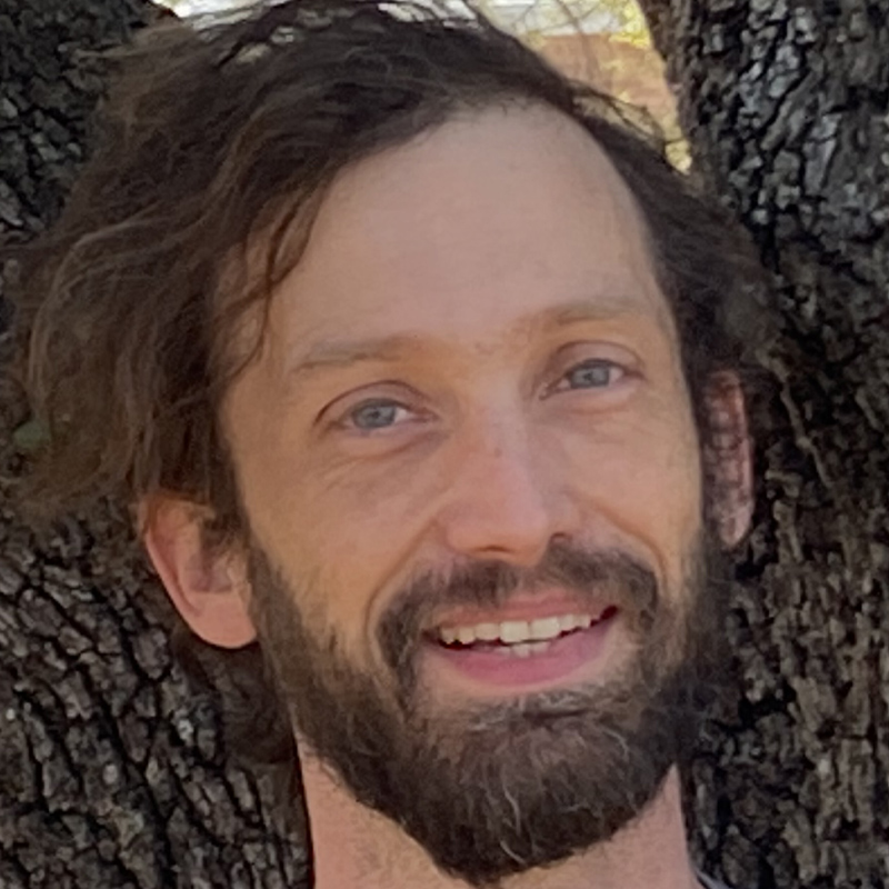 Scott smiling beneath a tree