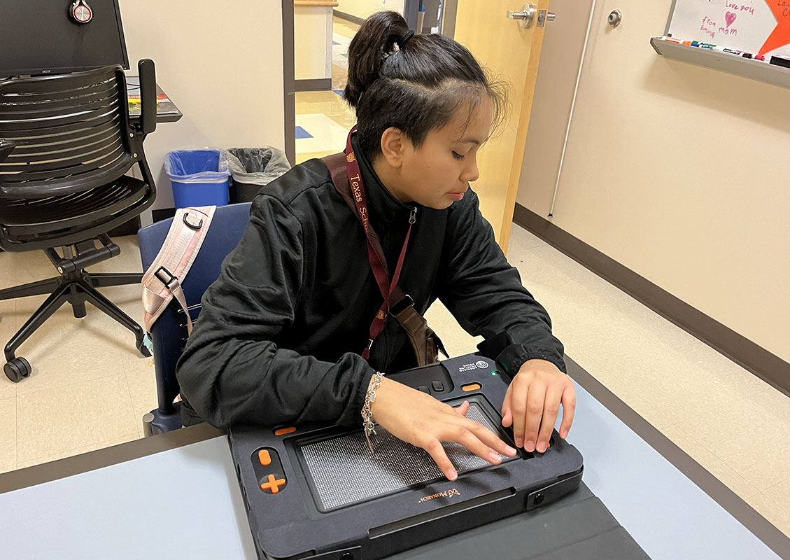 A student uses a Monarch braille display in a classroom.