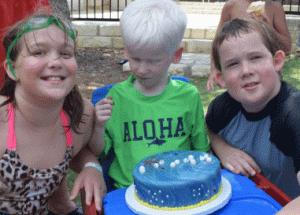 picture of boy with cake and siblings