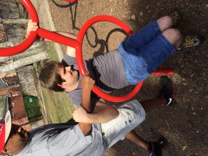 Christopher and his intervener enjoy outdoor play equipment