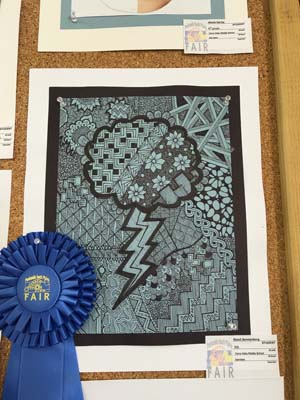 Scout’s black and white Zentangle drawing with the blue ribbon she won at the South Plains Art Fair.