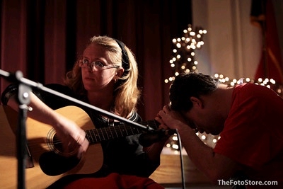 A deafblind secondary student leans forward in order to feel the vibrations from the guitar when Dr. Darst plays.