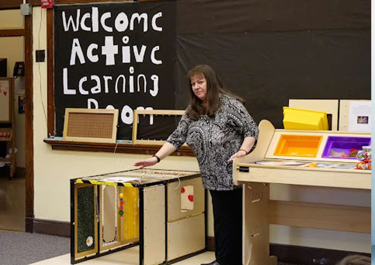 The Active Learning trainer stands between two large pieces of equipment.