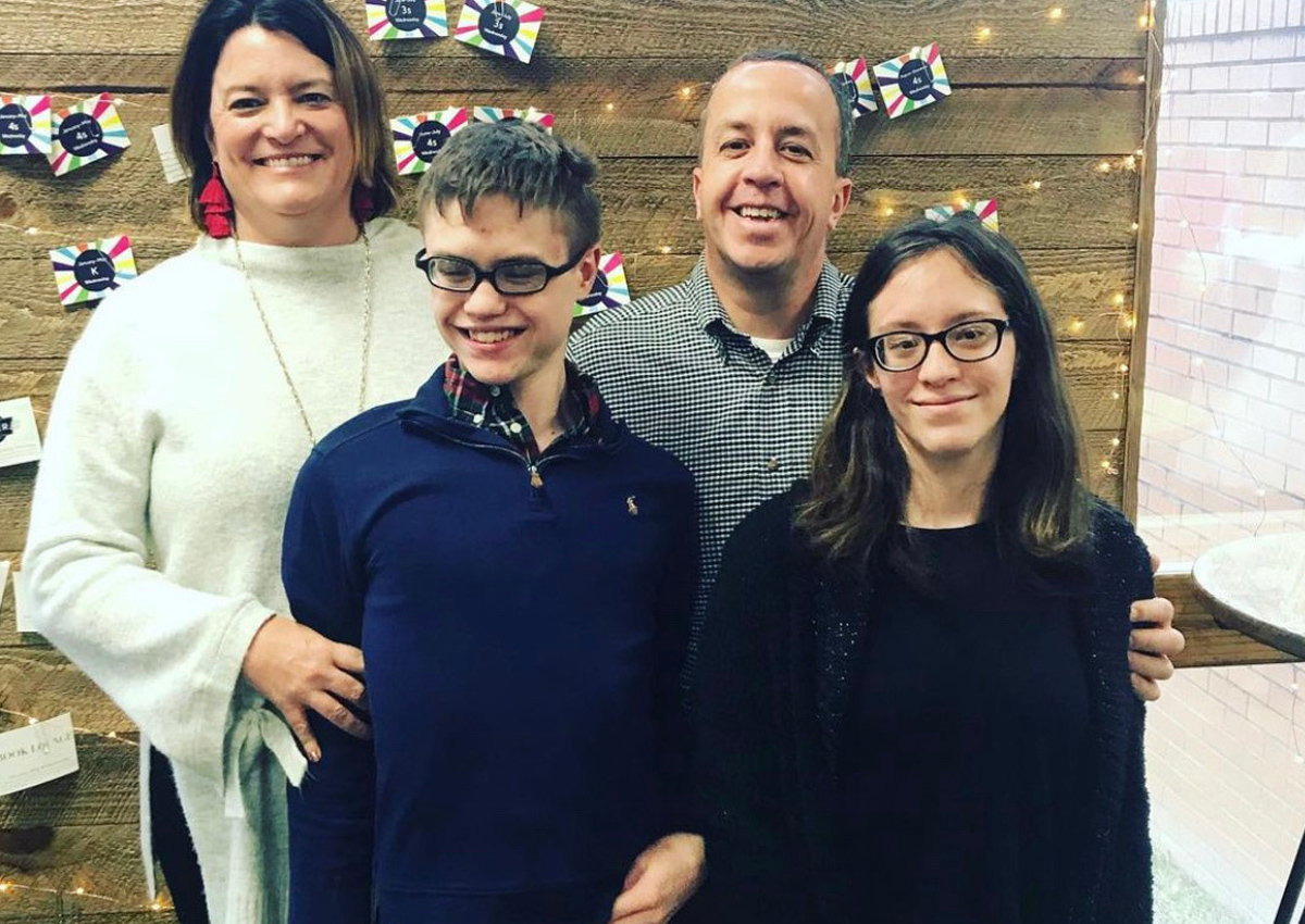 A family of four poses for a photo.